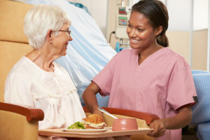 nurse serving food to an elderly woman
