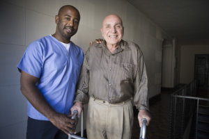 caregiver and elderly man walking